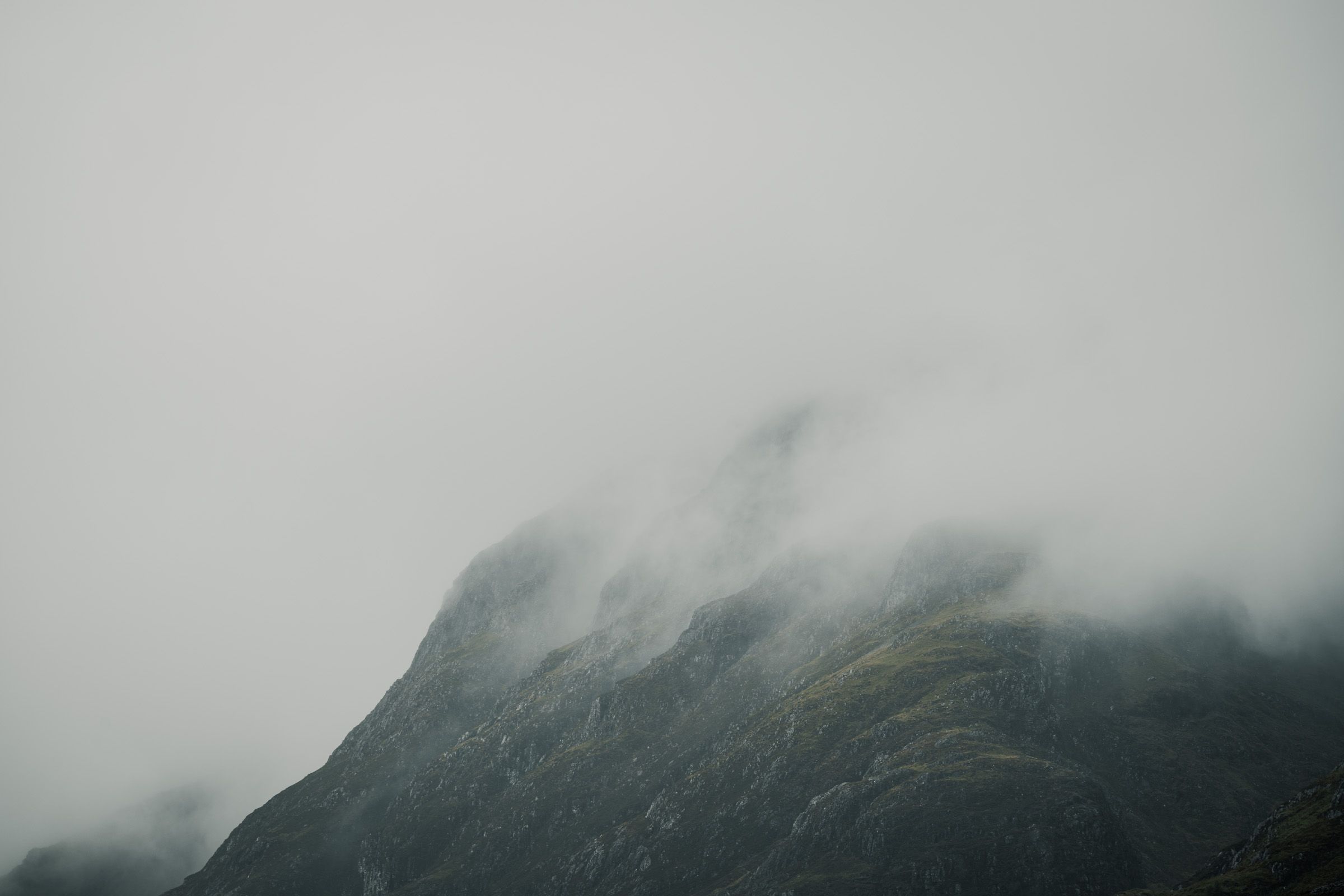 Stepped rocky ridge fading into thick mist