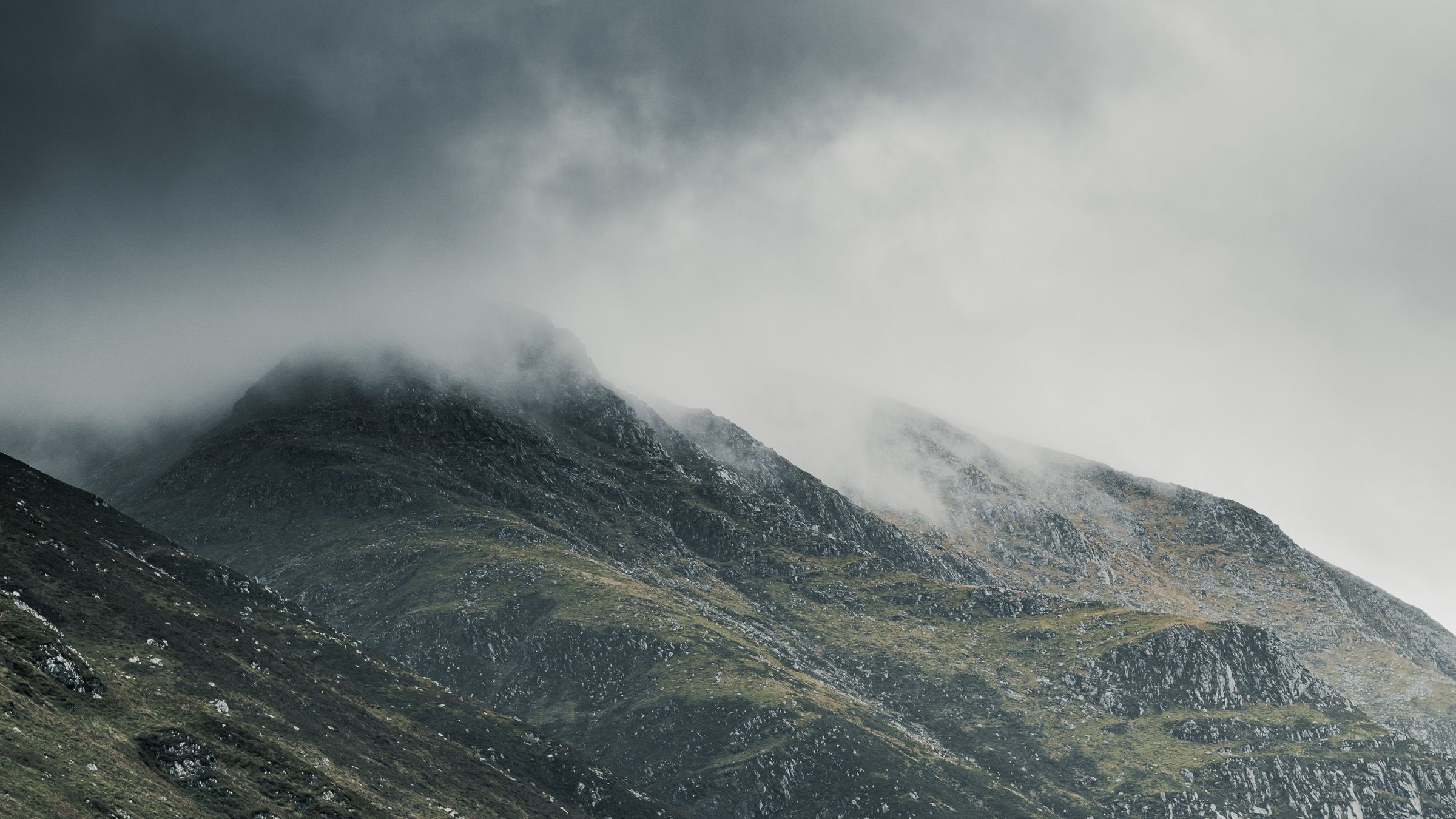 A rocky mountain peak half hidden in low cloud